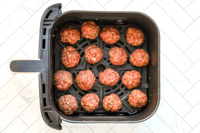 Shaped meatballs are in the air fryer basket.