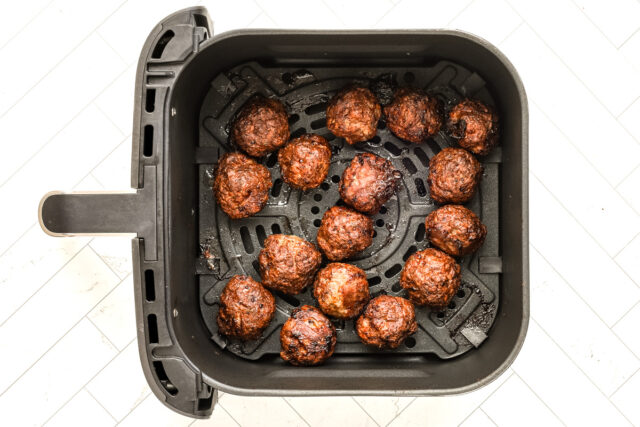 Shaped meatballs are in the air fryer basket.
