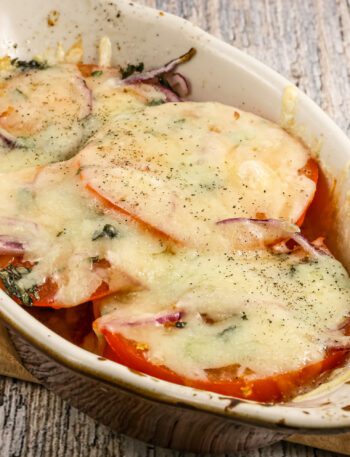 fresh baked tomatoes in a gratin dish with melted fontina cheese