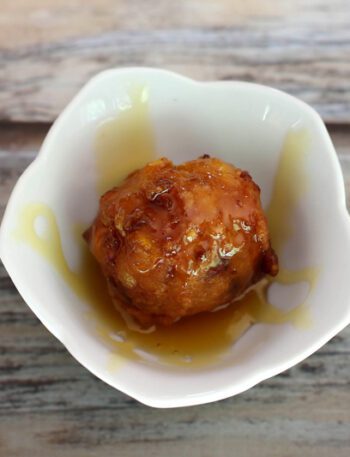 basic corn fritter in a small bowl with golden syrup