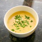 beer cheese soup with a parsley garnish.