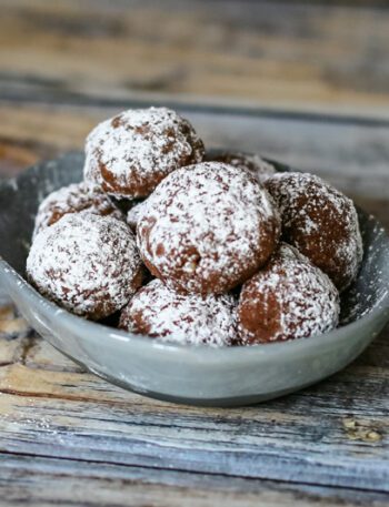 Chocolate butterball cookies in a small dish.