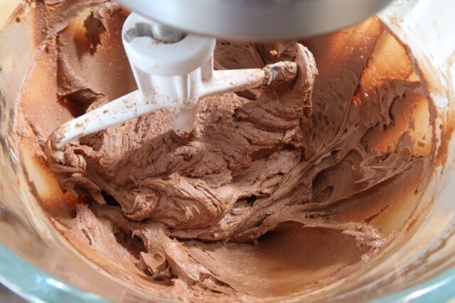 chocolate buttercream frosting in the bowl of a stand mixer