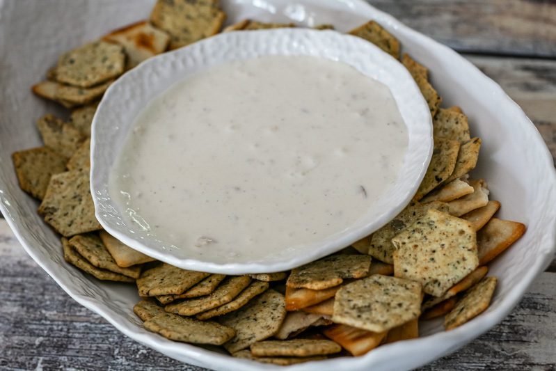 clam dip in a serving bowl with crackers