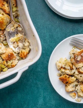 bread stuffing or dressing on a plate with baking dish on the side