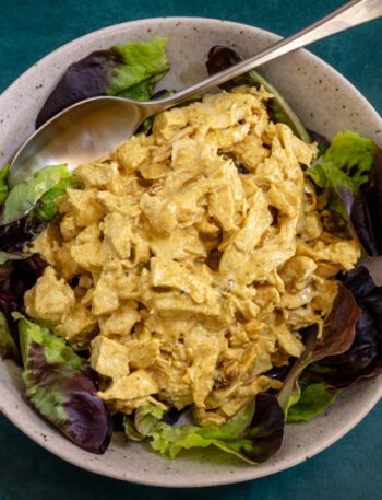 coronation chicken with curry powder in a lettuce-lined bowl