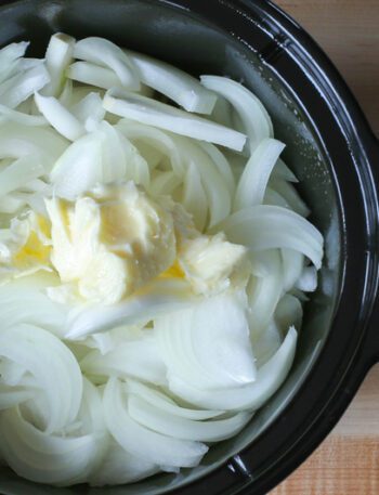 preparing slow cooker onion soup with onions and butter in the crockpot