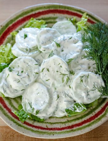 cucumber salad with sour cream and dill on a plate