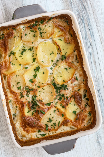 Baked dauphinoise potatoes with parsley garnish - potato gratin.
