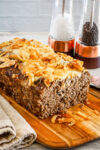 Sliced French onion meatloaf with Gruyère cheese and fried onion topping.