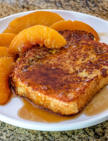 french toast on a plate with caramelized peaches