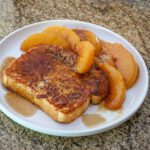 French toast with sliced caramelized peaches on a plate