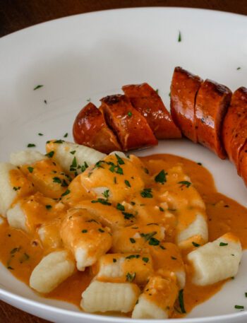 homemade gnocchi on a plate with andouille sausage and a sauce