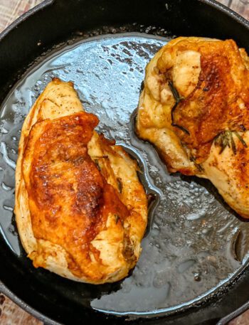 herb roasted split chicken breasts in a cast iron pan