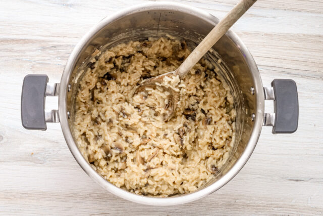 The Parmesan cheese and butter are added to the Instant Pot mushroom risotto mixture.
