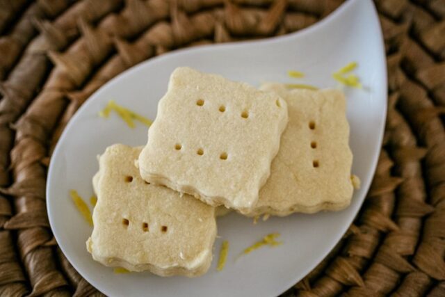 lemon shortbread cookies on a plate with lemon zest
