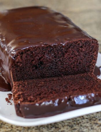 A chocolate loaf cake on a serving tray.