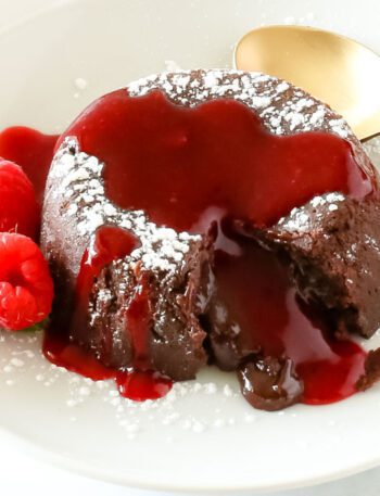 chocolate molten lava cake on a plate with raspberries and mint