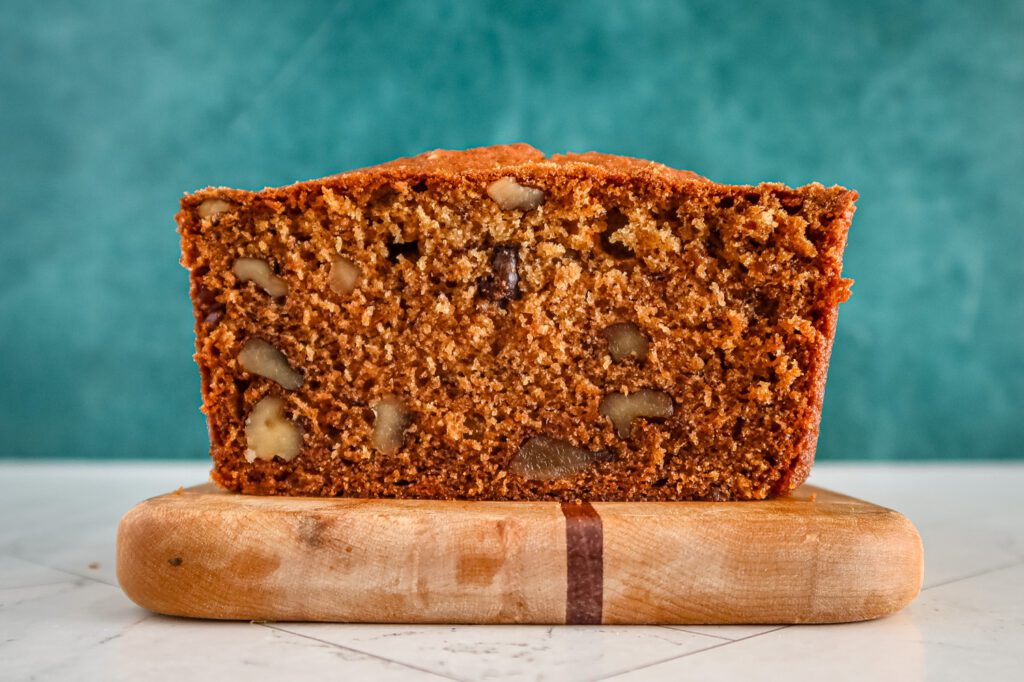 A loaf of one-egg banana bread sliced, showing the nuts and texture.