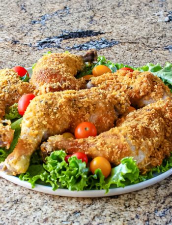 Cornflake crusted chicken on a platter with tomatoes and lettuce.