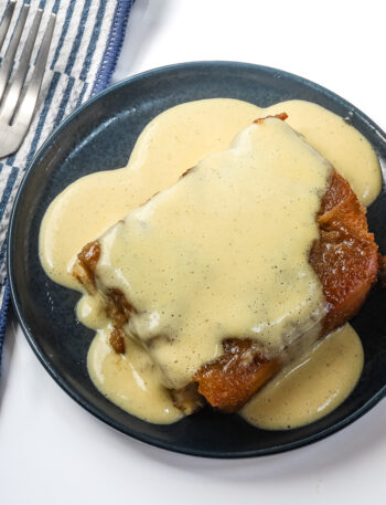 Overnight French toast served on a small plate with creme anglaise.