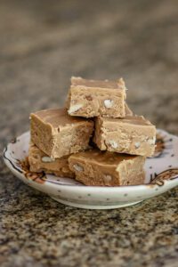 peanut butter fudge is stacked on a small plate
