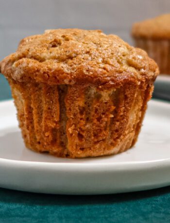 A pear muffin on a plate with more in the background