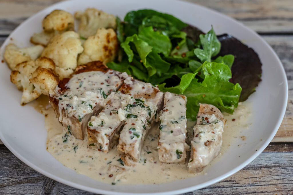 boneless pork chops are roasted and served on a plate with dijon mustard cream sauce
