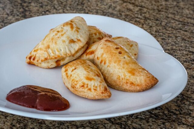 pulled pork empanadas on a plate with bbq sauce