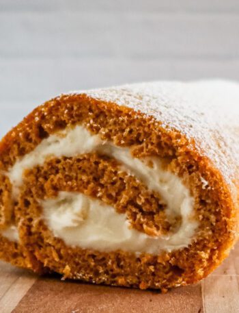 pumpkin cake roll with cream cheese filling on a cutting board