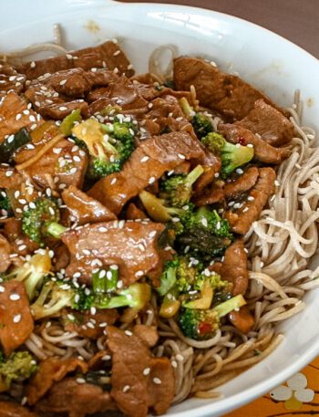 sesame noodles in a bowl with a meat stir-fry