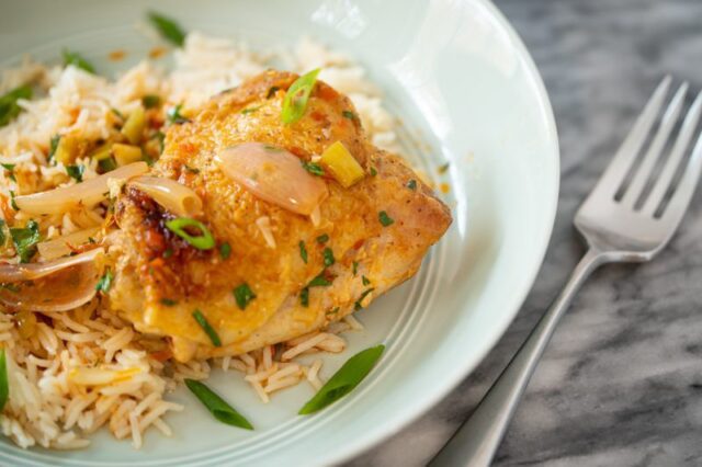 harissa chicken served over rice with its sauce