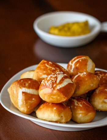 soft pretzel bites with mustard for dipping in the background