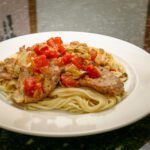 veal cutlets with tomatoes and artichokes on pasta