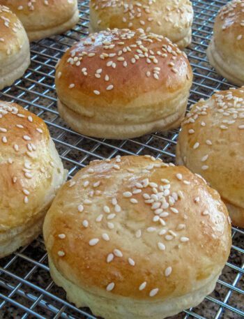 hamburger buns with sesame seeds on a cooling rack